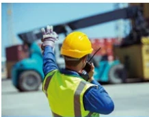 Port worker coordinating container handling by radio